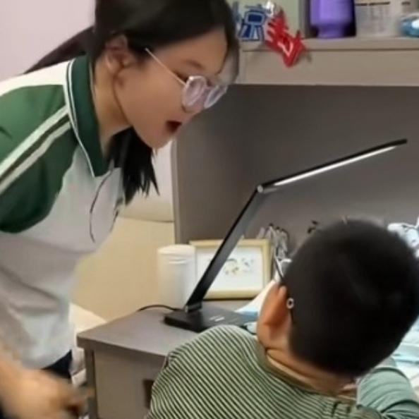 4月16号晚，姐姐早早写完作业在预习，弟弟却对着作业愁眉苦脸。妈妈怕自己辅导又发