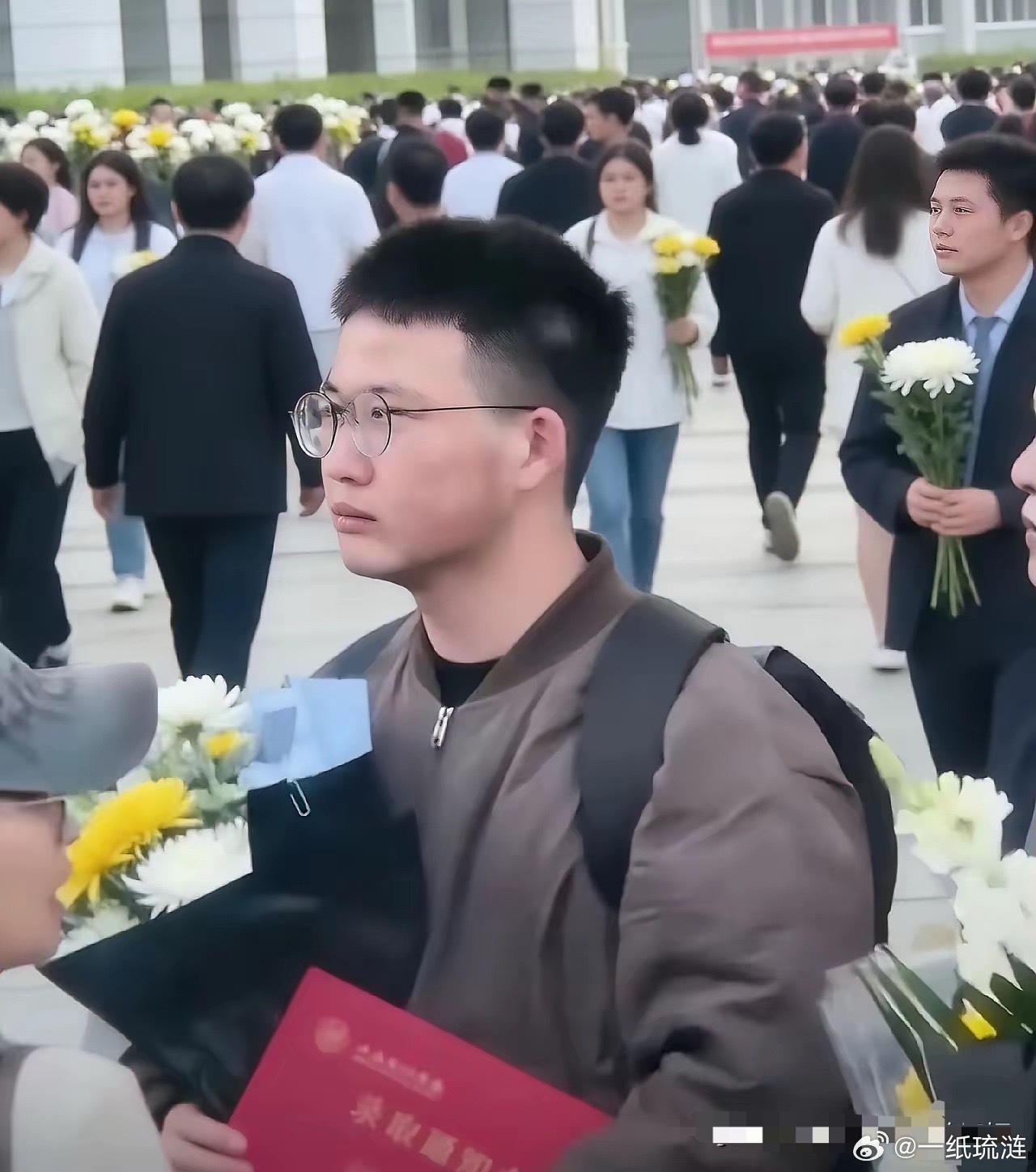 背着起毛边的双肩包，死死捏着那张录取通知书。这小伙子远赴苏州。站在人群中憋着嘴角