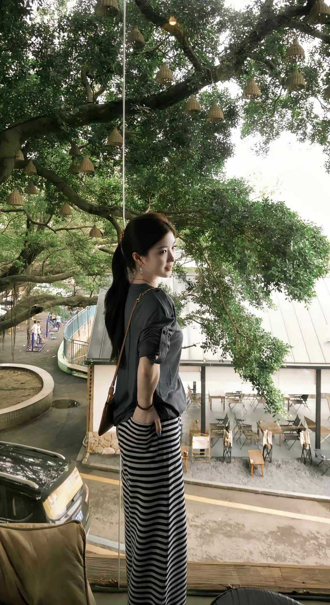 这姑娘站在咖啡馆的窗边，风景真美。