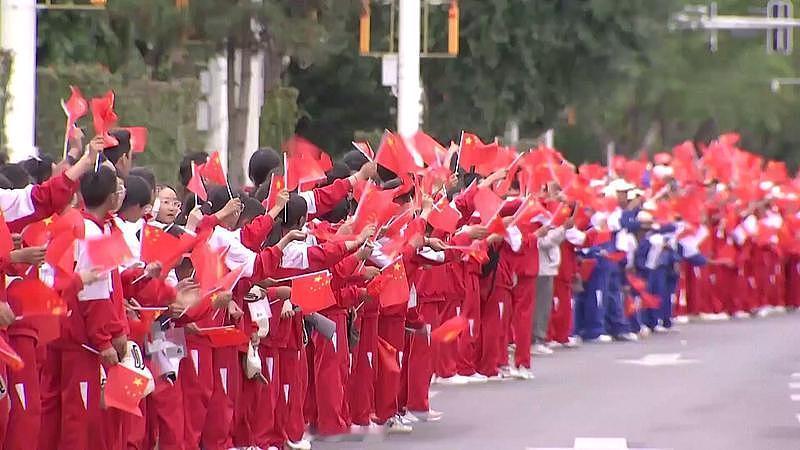 国庆走在街头，看着主干道两旁从人民广场一直延伸到滨江路的五星红旗连成流动的红浪，