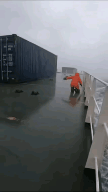 不知道这是在路上还是在船上，这风也太大了，被吹起来的这个东西像是一个集装箱，直接