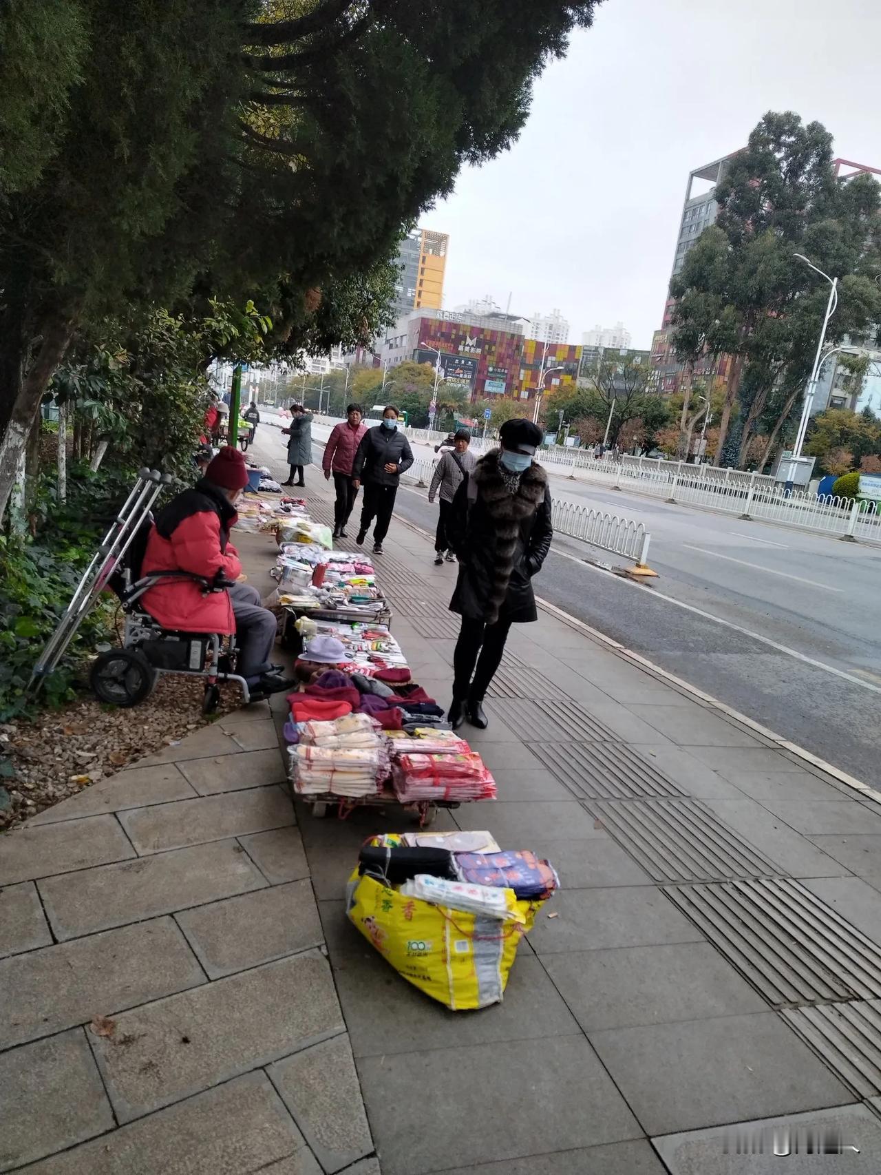 气温骤降，寒气逼人。为了生活，继续摆摊。图为昆明路边摆摊老人。