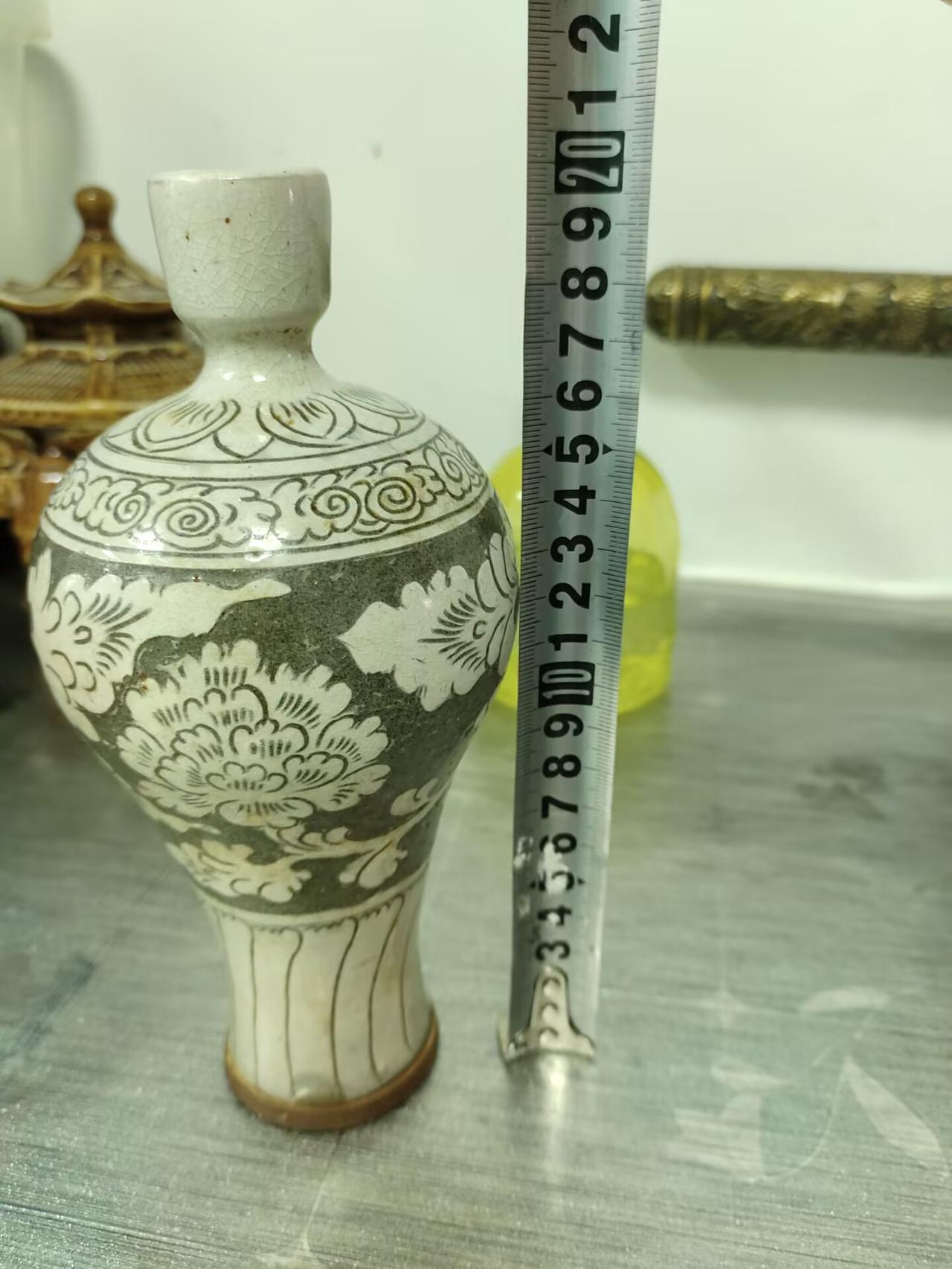 宋金磁州窑黑地白花剔花小梅瓶鉴赏
 
此瓶为宋金磁州窑制品，通高20厘米，口径3