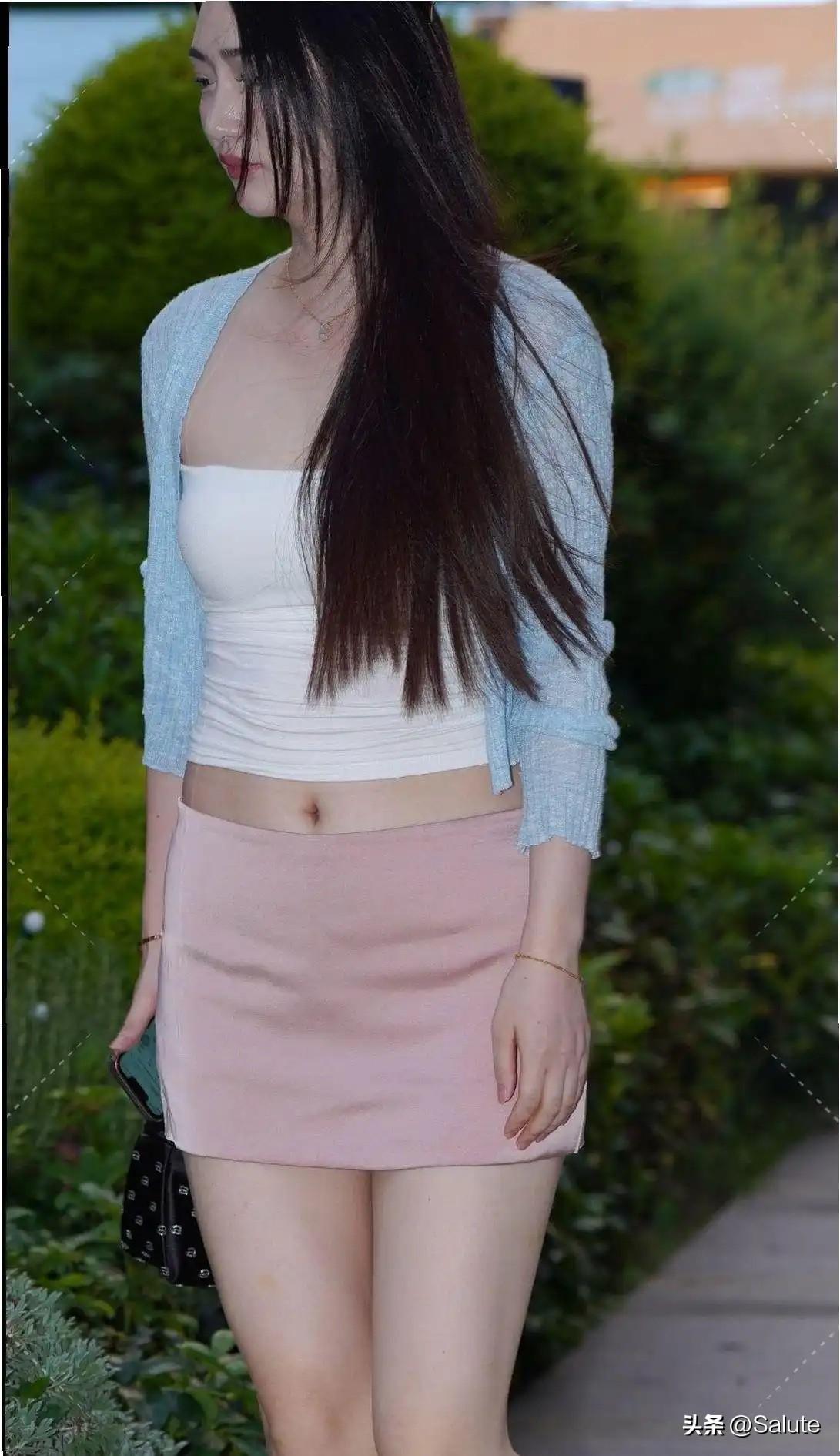 这姑娘穿着蓝衬衫和粉色裙。