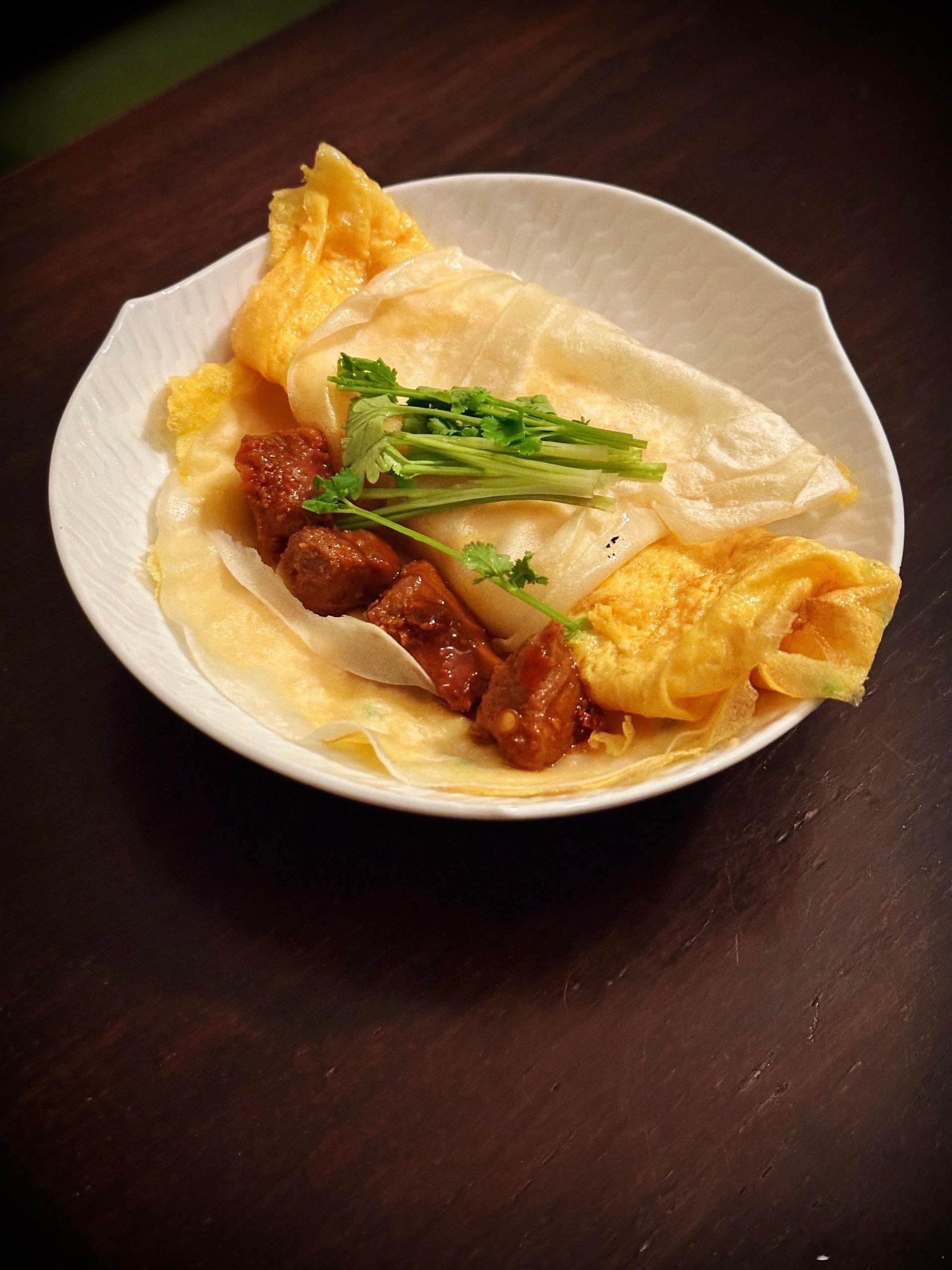 买烤鸭的时候呢，可以多买一份薄饼。摊个葱花蛋饼，上面放一片薄饼，翻一面再放一片薄