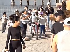 街头围观机器人的画面在中国已是平常场景，但不寻常的是这幅图片上的一幕不在中国，而