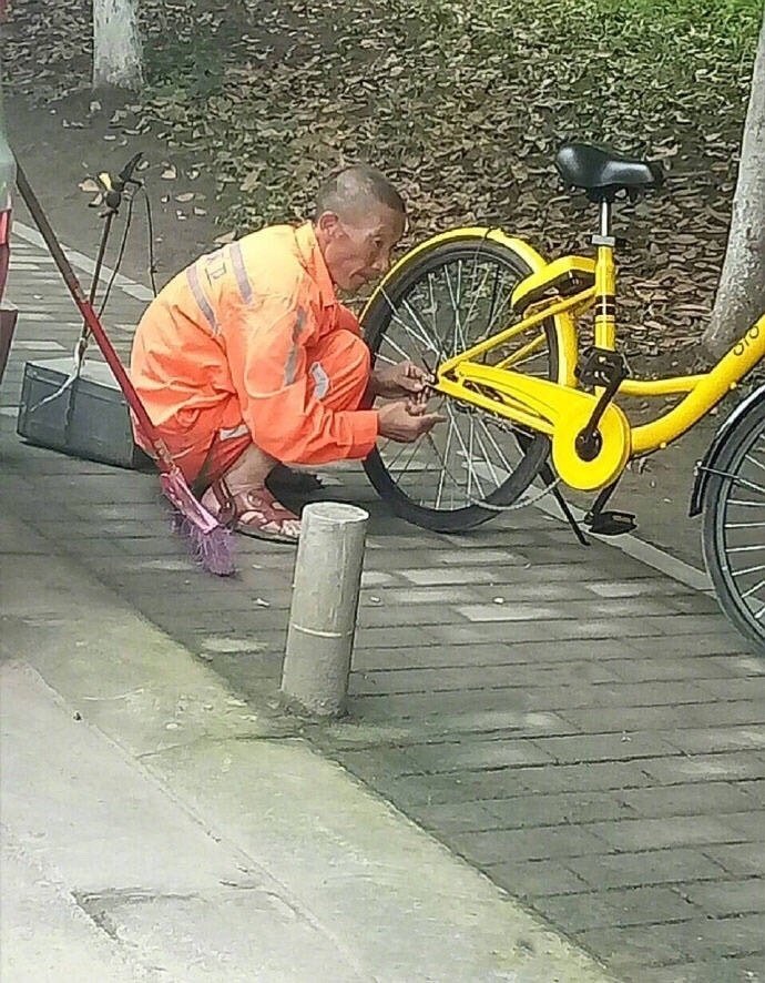 网友拍到的一幕：成都街边一环卫大爷正在给共享单车上链条。愿世间的好人都能被时光善