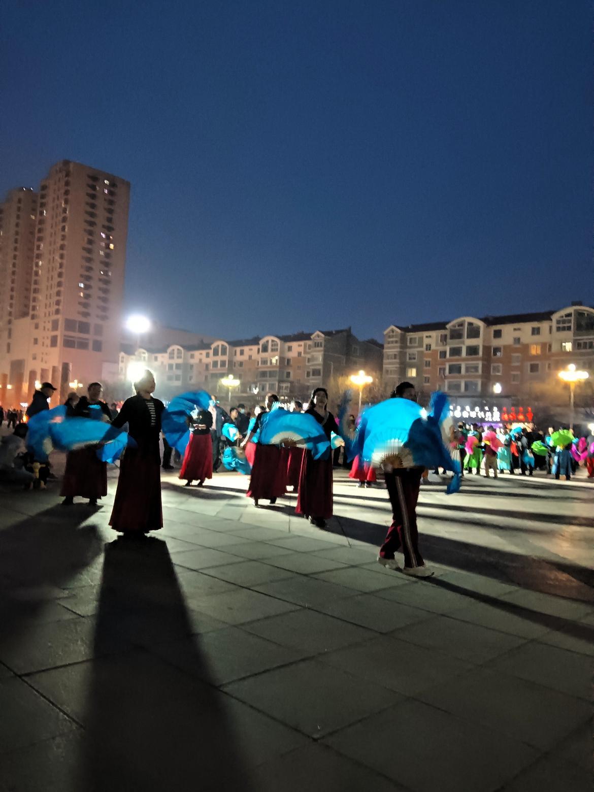 一群人在广场上扭秧歌，热闹极了！真是舞出青春，舞出健康啊！