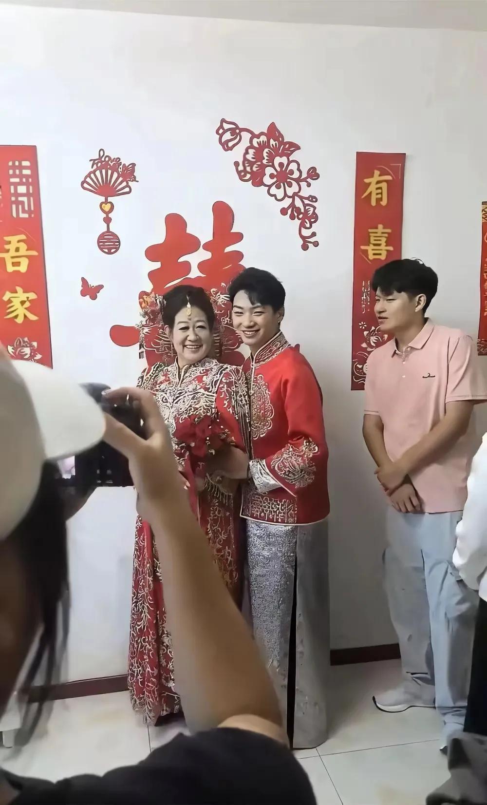 结婚现场，一对新人正在兴高采烈地拍照，这对新人不一般，一眼就看到新娘年龄要比新郎
