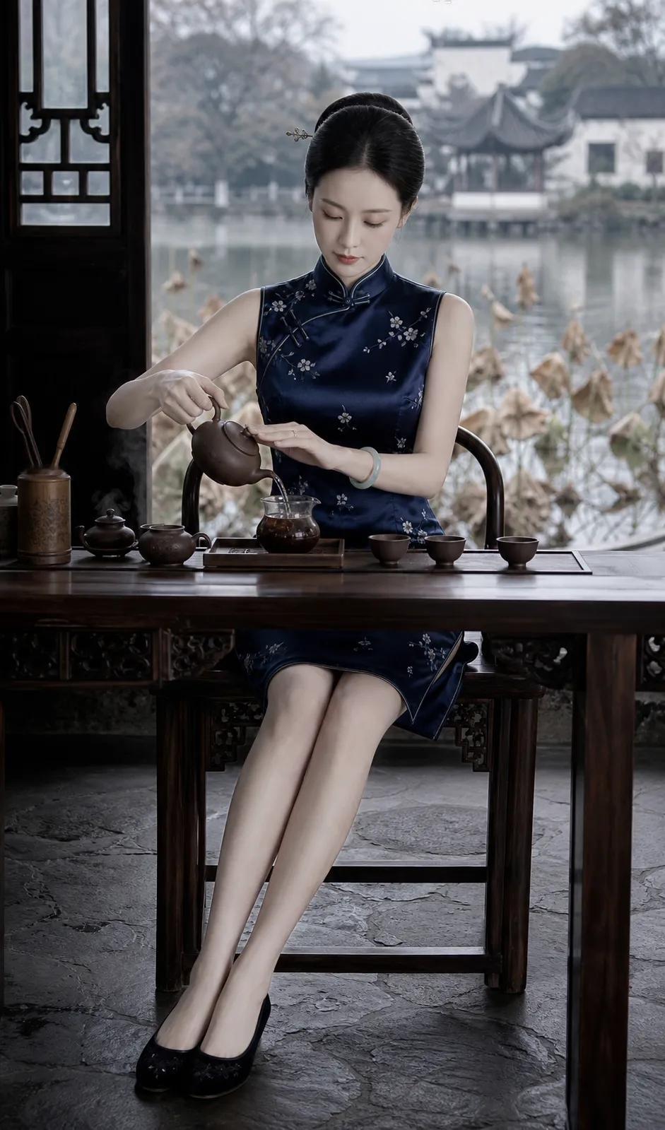 一袭深蓝旗袍裹着温婉身段，无袖剪裁露出纤细臂弯，开衩裙摆间，修长双腿若隐若现。她