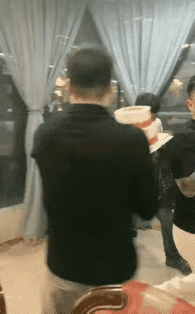 白衣男子过生日，哥们朋友都来给他过生日，其中有一个黑衣男子拿着生日蛋糕扣在了白衣