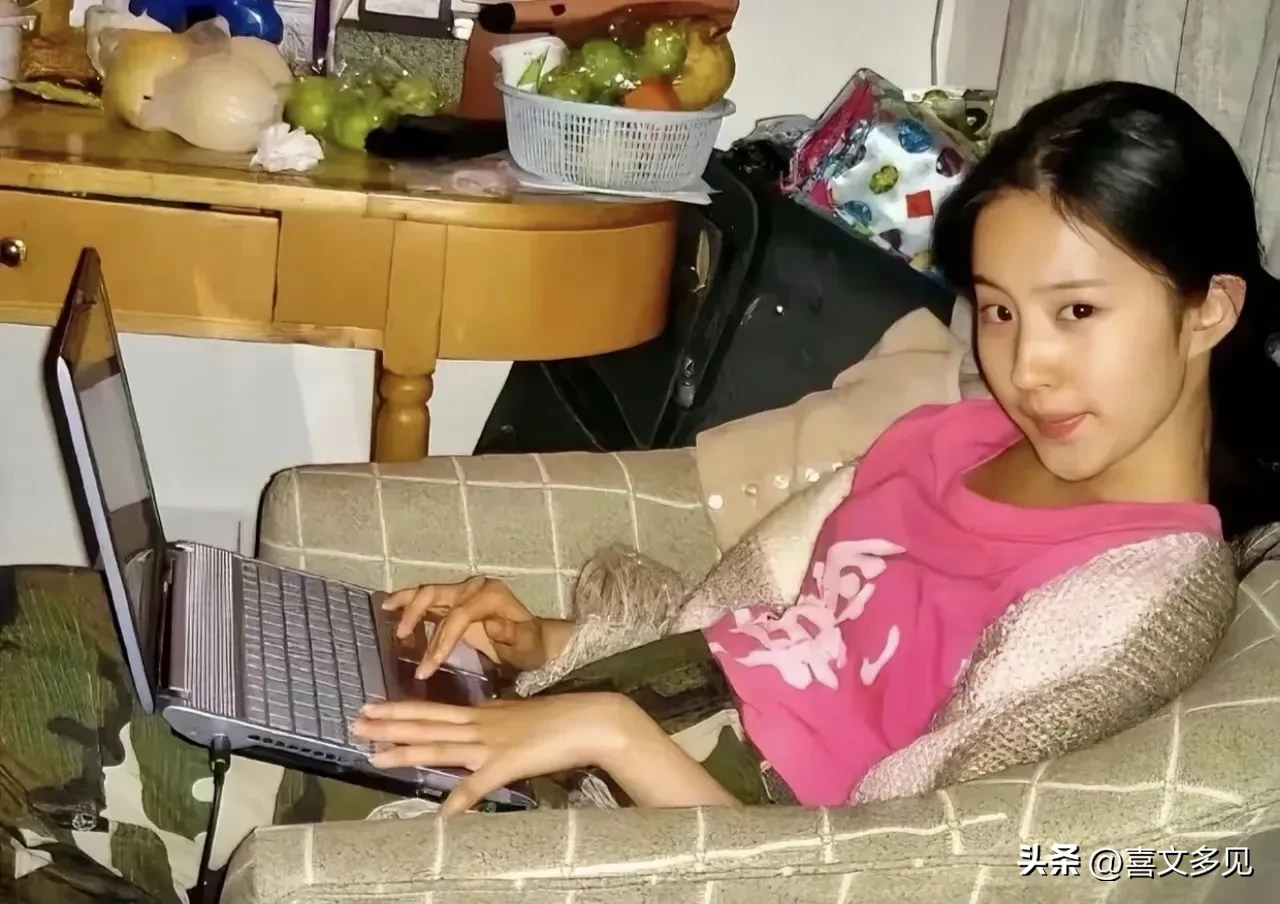 15岁的刘亦菲素面朝天，拿着相机和笔记本，绝不是一般人家。这张照片拍摄于2002