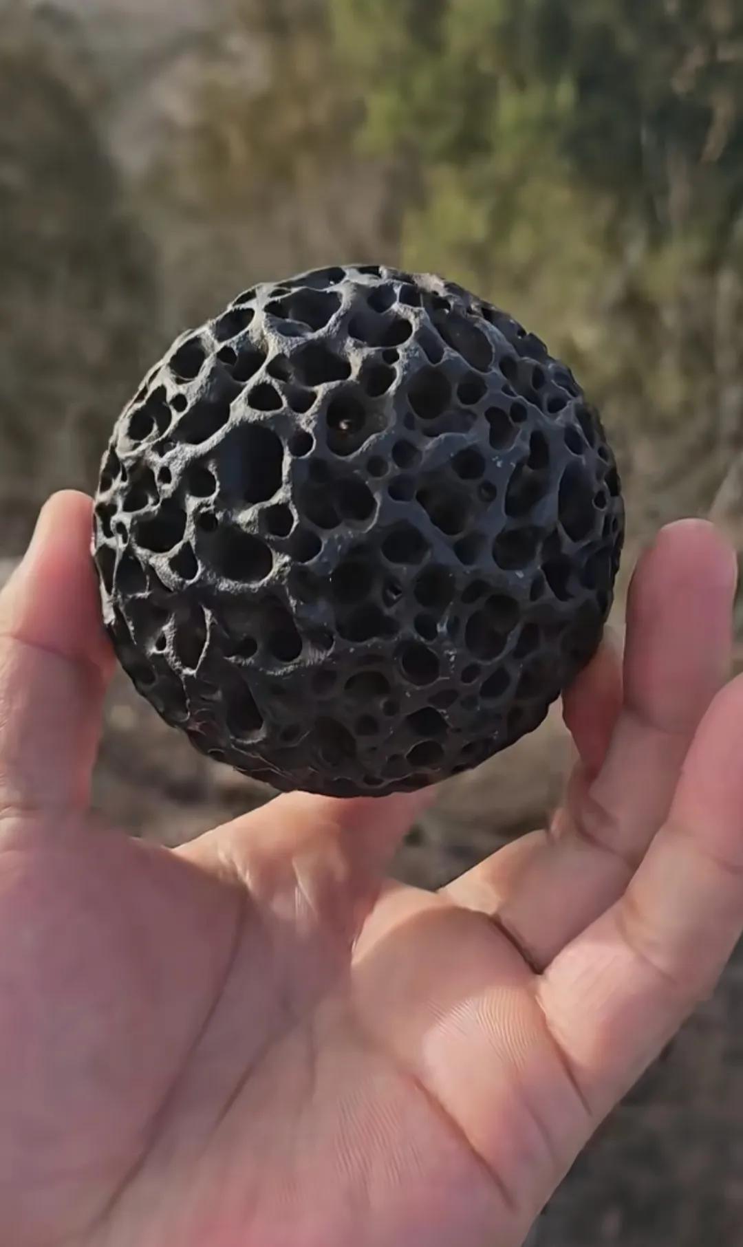 山里面捡到一块黑色的石头，上面有自然形成的孔洞，请大神们帮忙看看这到底是个啥石头