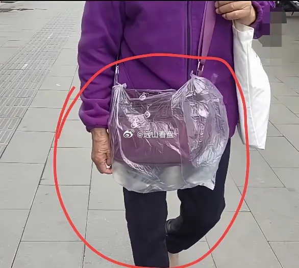 这个我属实没有看懂，大妈背个包，为什么上面还要套一个塑料袋呢？这个塑料袋到底做什