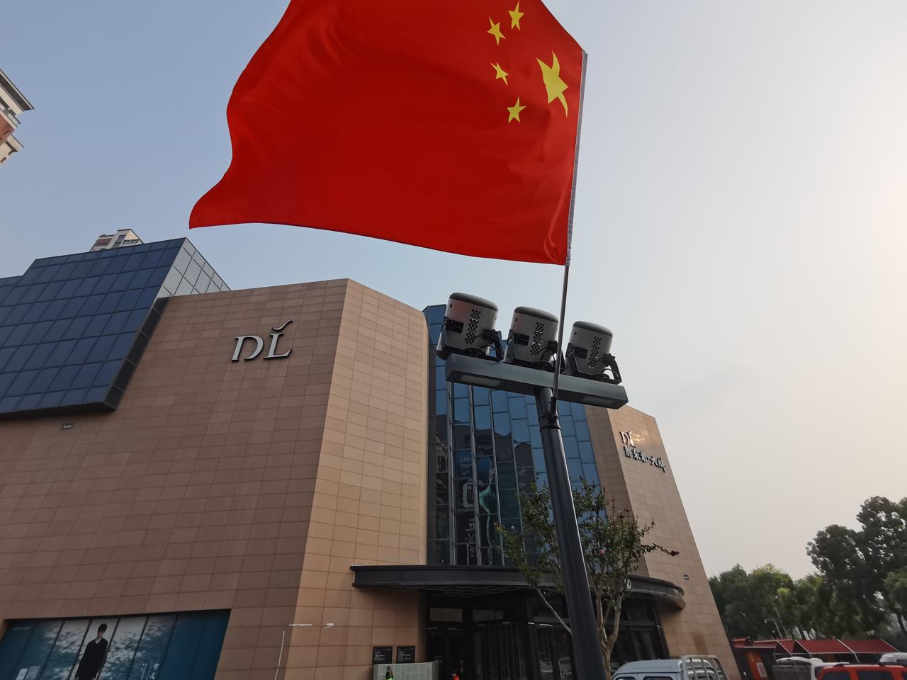 路过胖东来三个店，广场上一片火红，每个灯杆上都高高地插着五星红旗。
望着一面面迎