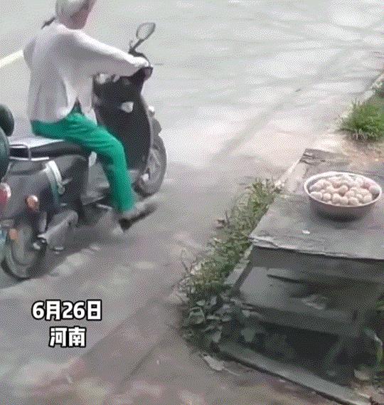 河南，一位农户将整盆大蒜置于自家门口晾晒，一名女子骑电动车经过后突然停下，四下张
