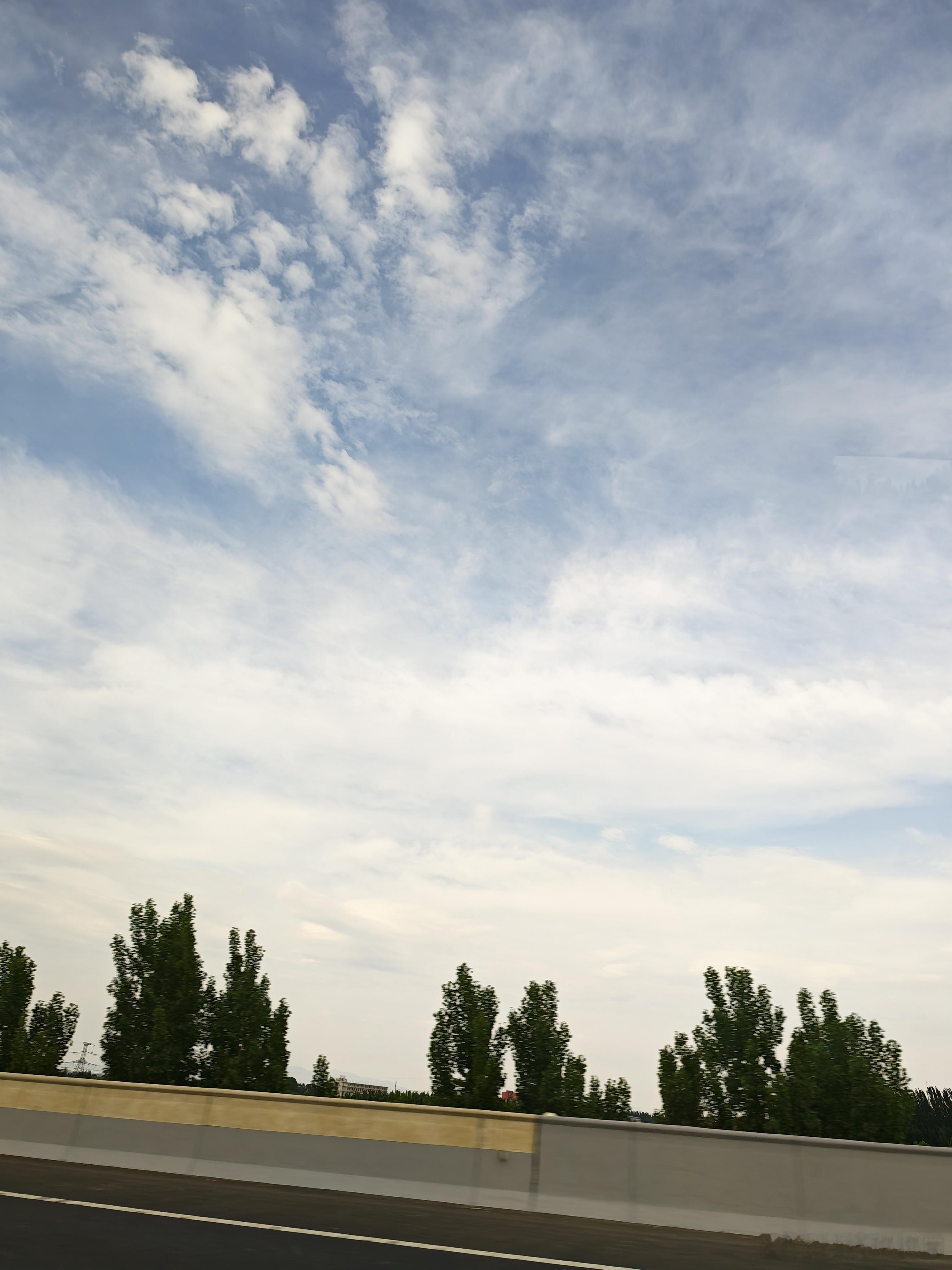 沿途的风景 天空如画布，云朵是自由的笔触，绘出无边的想象。公路延展，像一条银色的