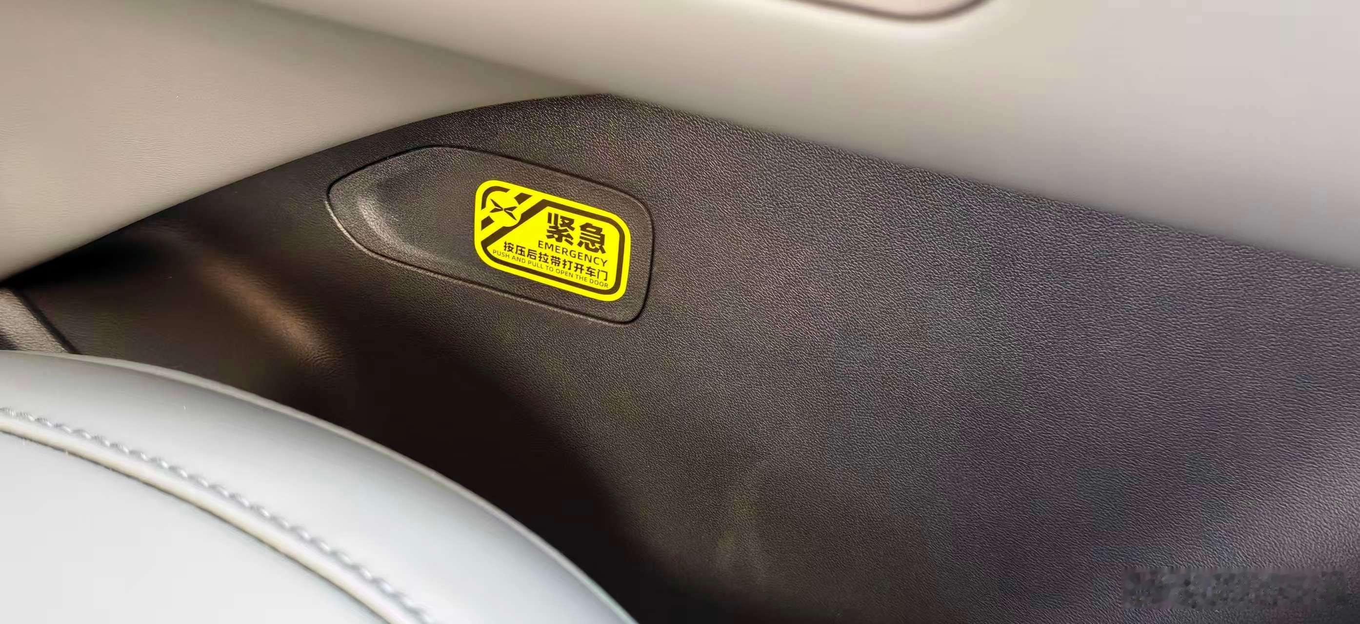 2026款小鹏p7+在车内的机械应急门把手处贴了黄色的警示贴纸，很显眼，这个细节