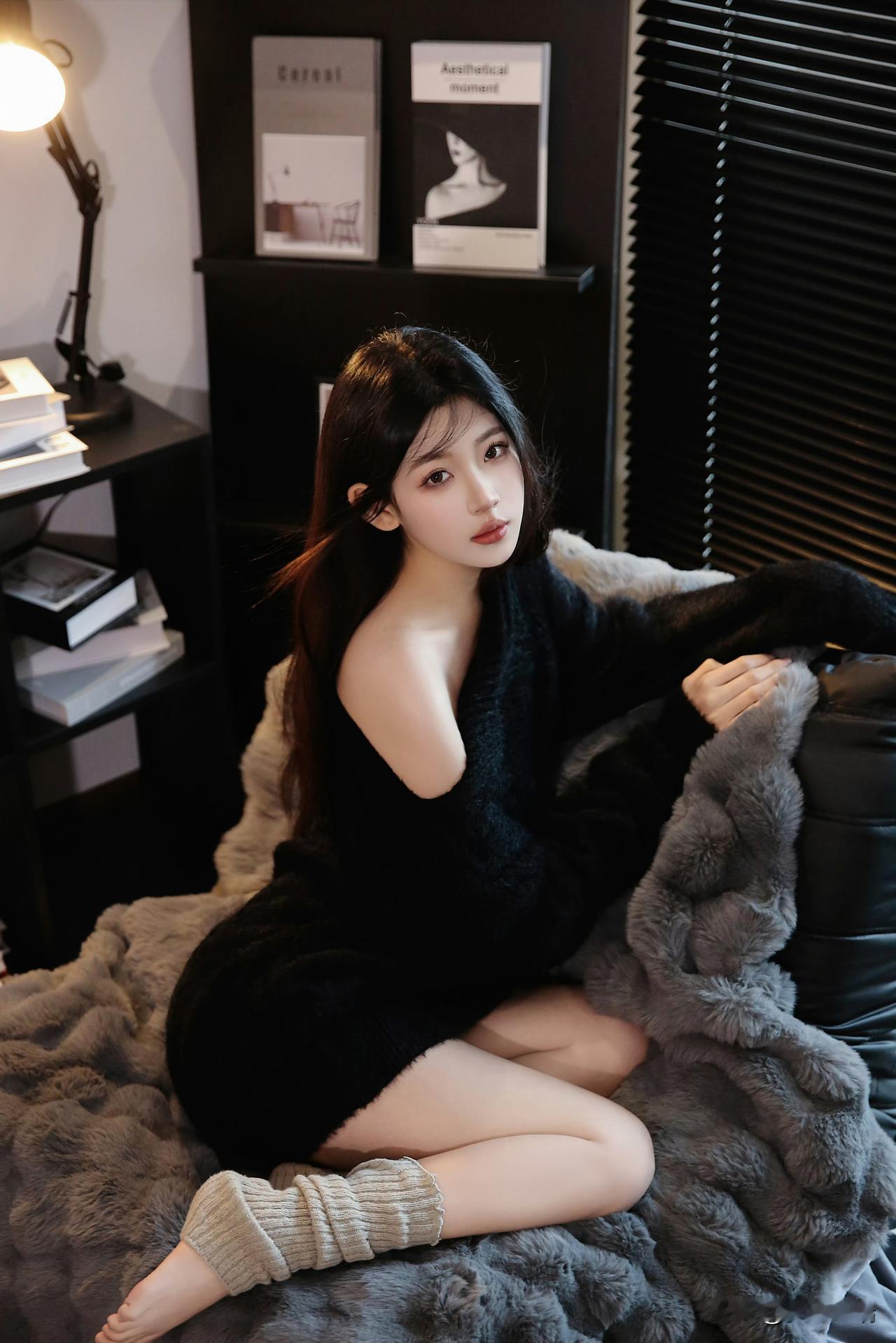 慵懒冬日，黑衣少女依靠在毛绒靠垫上的温馨时光。