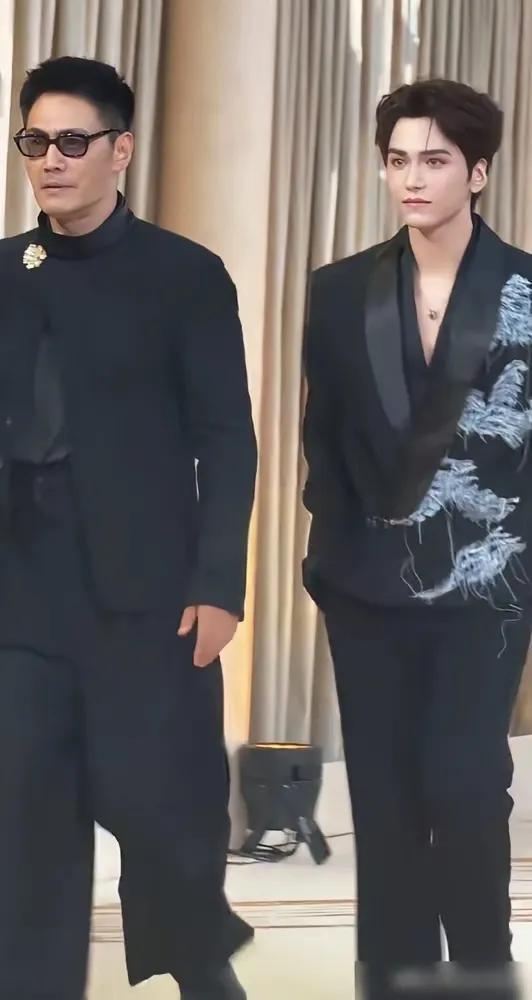 五十八岁的邵兵和二十二岁的儿子邵子恒同台，一样的黑西装，个头也相近，可往那一站感