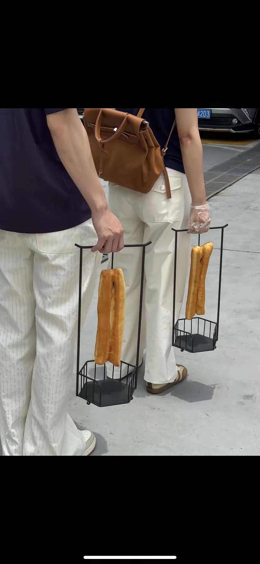 一线城市，广州，不愧是美食之都啊！
这油条挂在一个架子上，身价瞬间暴增，消费者趋