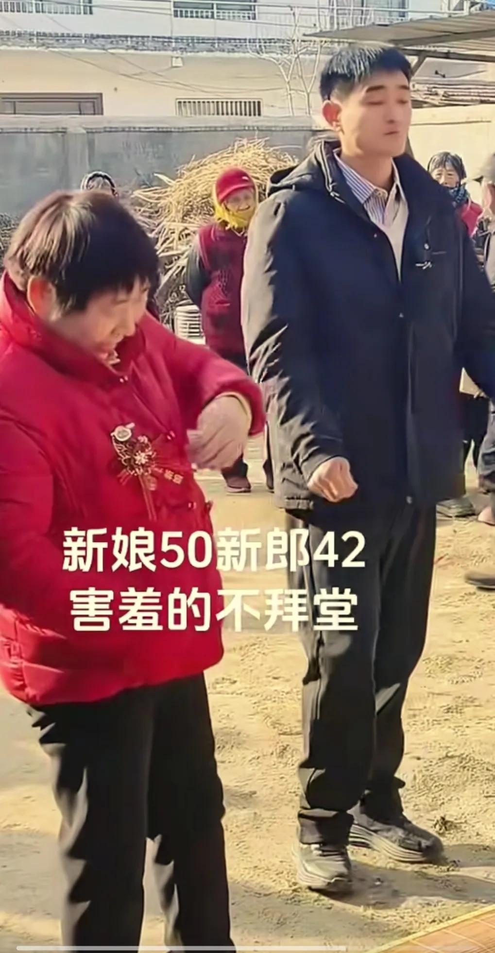 新郎长得高大帅气，因为家贫，42岁才好不容易找到一个50岁的老婆。
新娘还害羞的