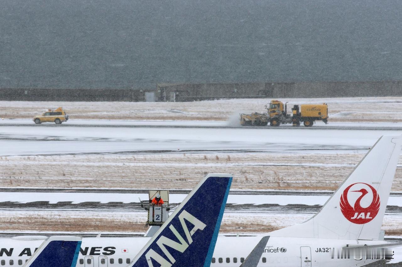 近日，日本遭遇寒流，日本中部国际机场在雪后实施除雪和机体防冰作业。