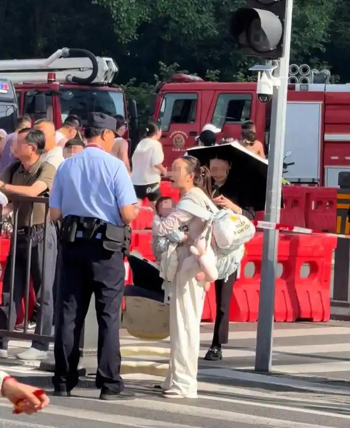 背着大包、怀里抱着娃、手上还拎着儿童座椅，三十多度的大太阳底下，就想过个马路，硬