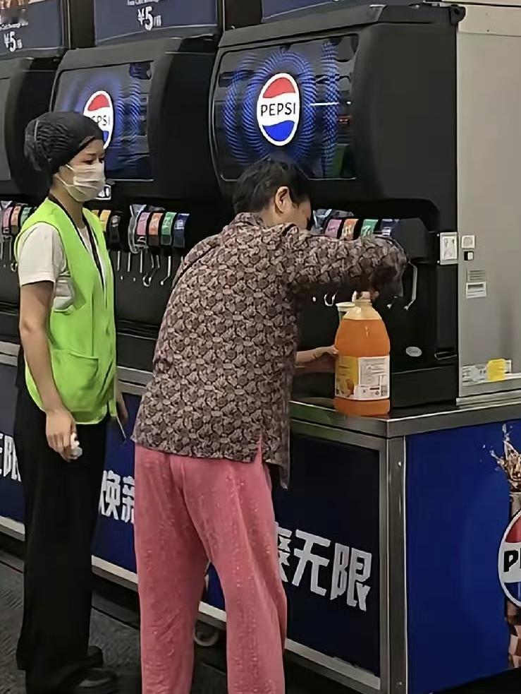 一位大妈自带大容量水桶，在武汉山姆会员店自助饮料机前“疯狂续杯”，工作人员劝都劝