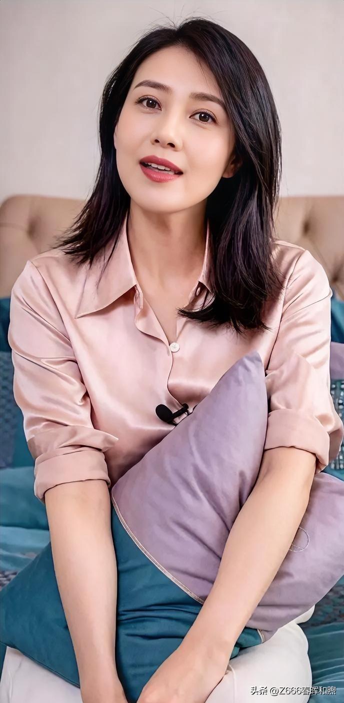 柔粉衣袂裹着温婉，青丝垂落如瀑。她拥枕而立，眸光澄澈，唇角噙着浅笑，似春风拂过心