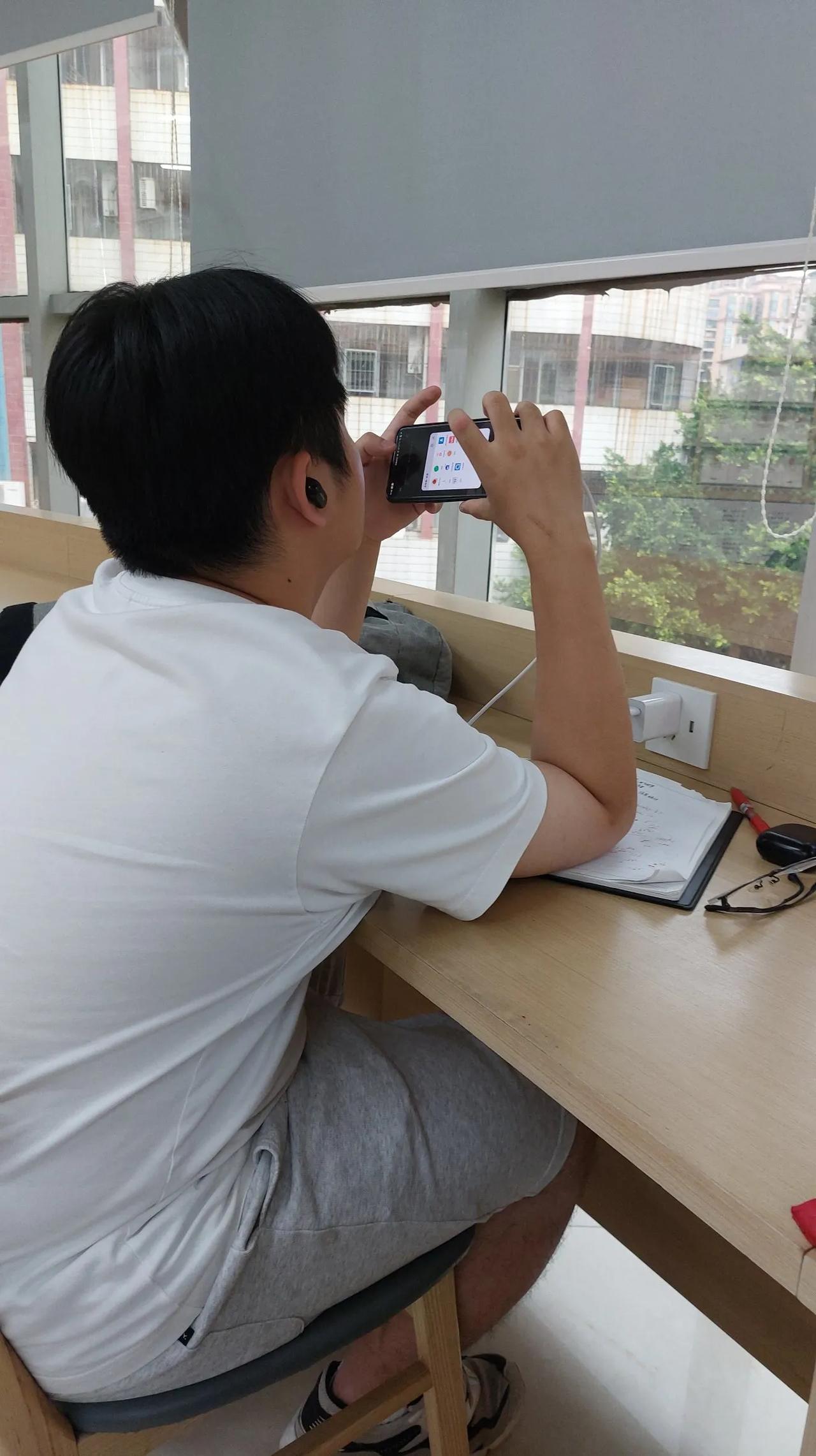 沉浸式玩游戏，这位小哥正享受着沉浸式玩游戏带来的快感，不知是什么品牌的手机，玩游