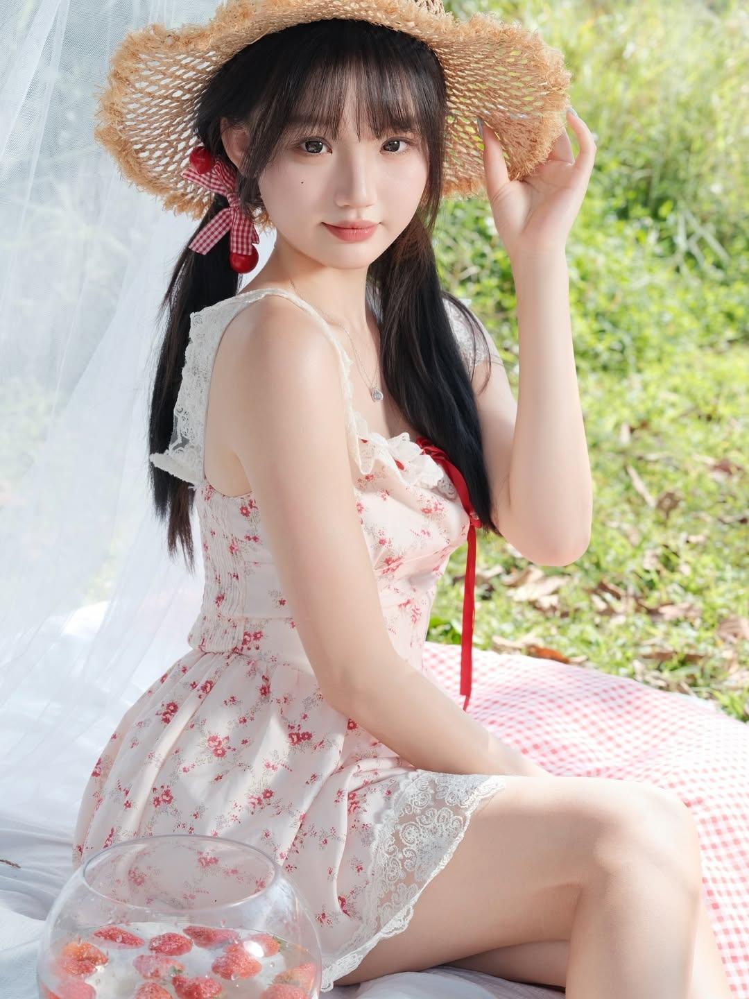 一个女孩在户外戴草帽拍照。