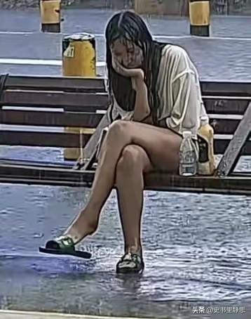 昨天广东惠州街头下起瓢泼大雨，路边长椅上的一幕看得人心头发酸。一个姑娘孤零零坐在