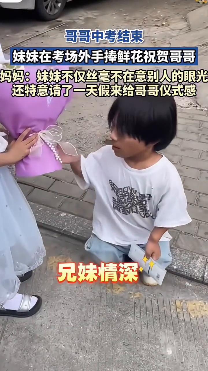 哥哥中考结束，妹妹在考场外手捧鲜花祝贺哥哥。妈妈：妹妹不仅丝毫不在意别人的眼光，