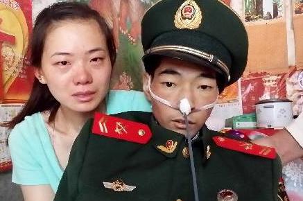 照片上的这个人身穿军装，骨瘦如柴，他此刻强打起精神，与妻子一起拍下了人生中最后的