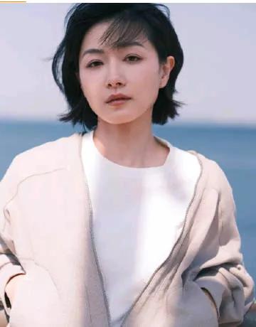 万茜的穿搭尽显简约清新，她身着一件米色或淡卡其色的浅色外套，款式简洁大方，没有过