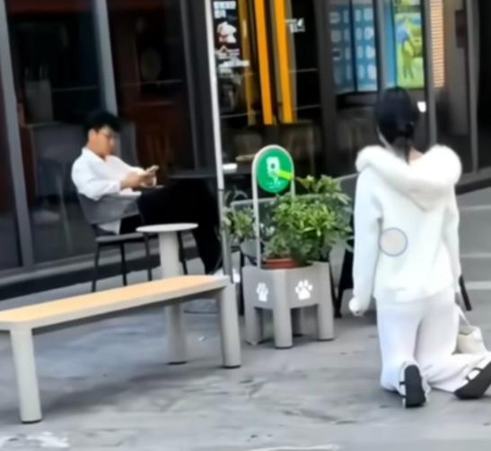 5月16日上海街头，女子当街跪地，男子全程低头玩手机。
 
这事发生在5月16日