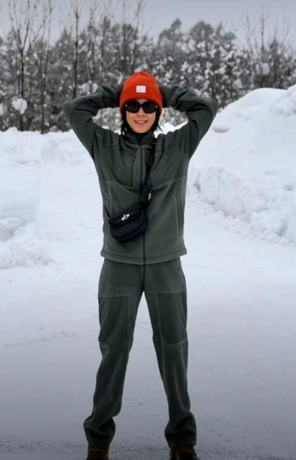 60岁刘嘉玲，雪地里一件薄衫。
 

她站在北海道齐膝的雪中，一身暗绿，头顶一抹