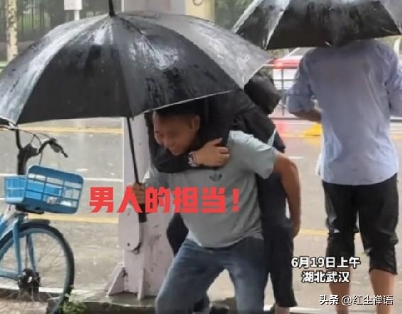 男子暴雨中撑伞，背妻前行，好样的！

6月19日上午，武汉暴雨瓢泼。湖北武汉洪山
