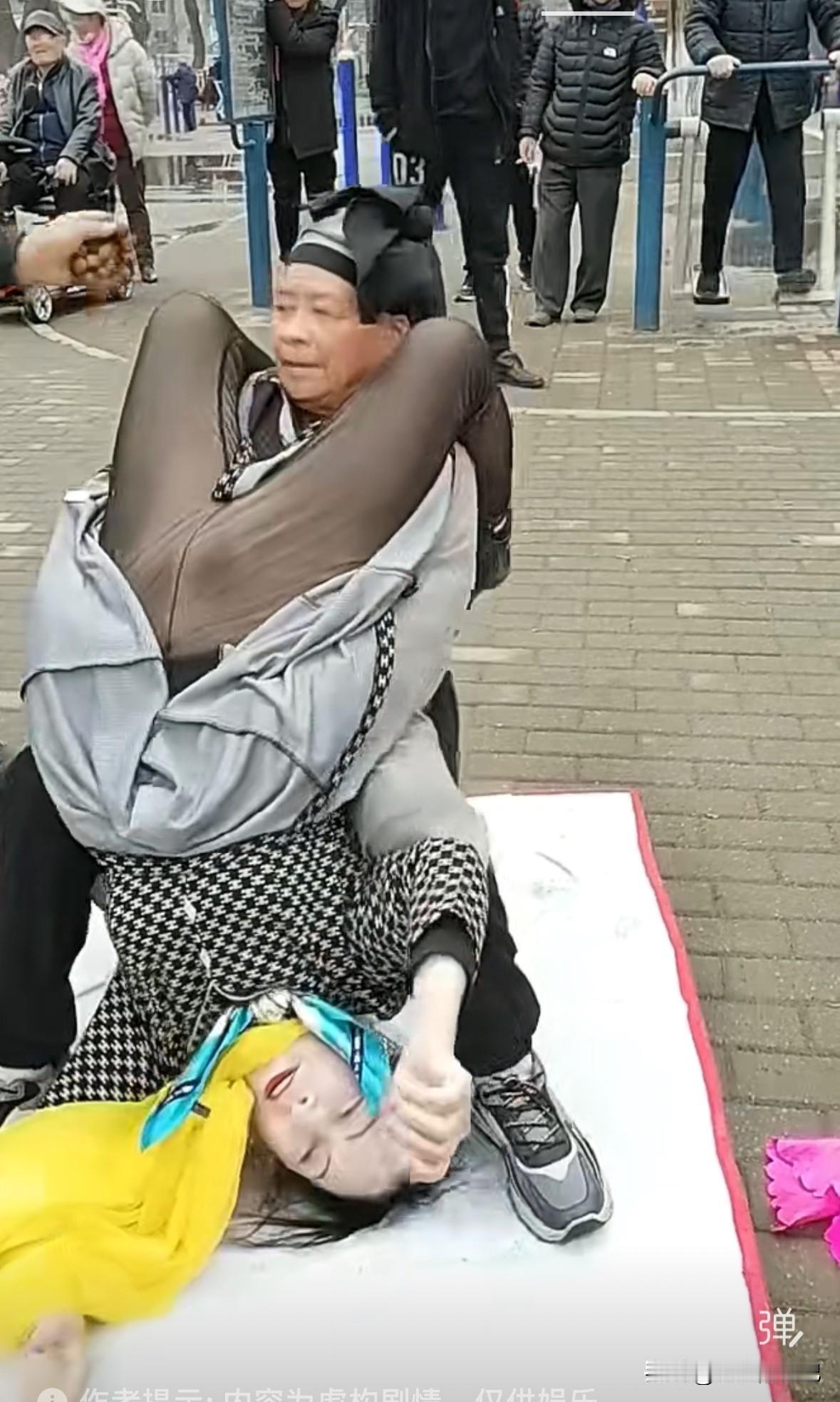 大爷坐在椅子上，大妈头朝下，臀部放在大爷的大腿和胸部，手撑着地面，因为撑不住，头
