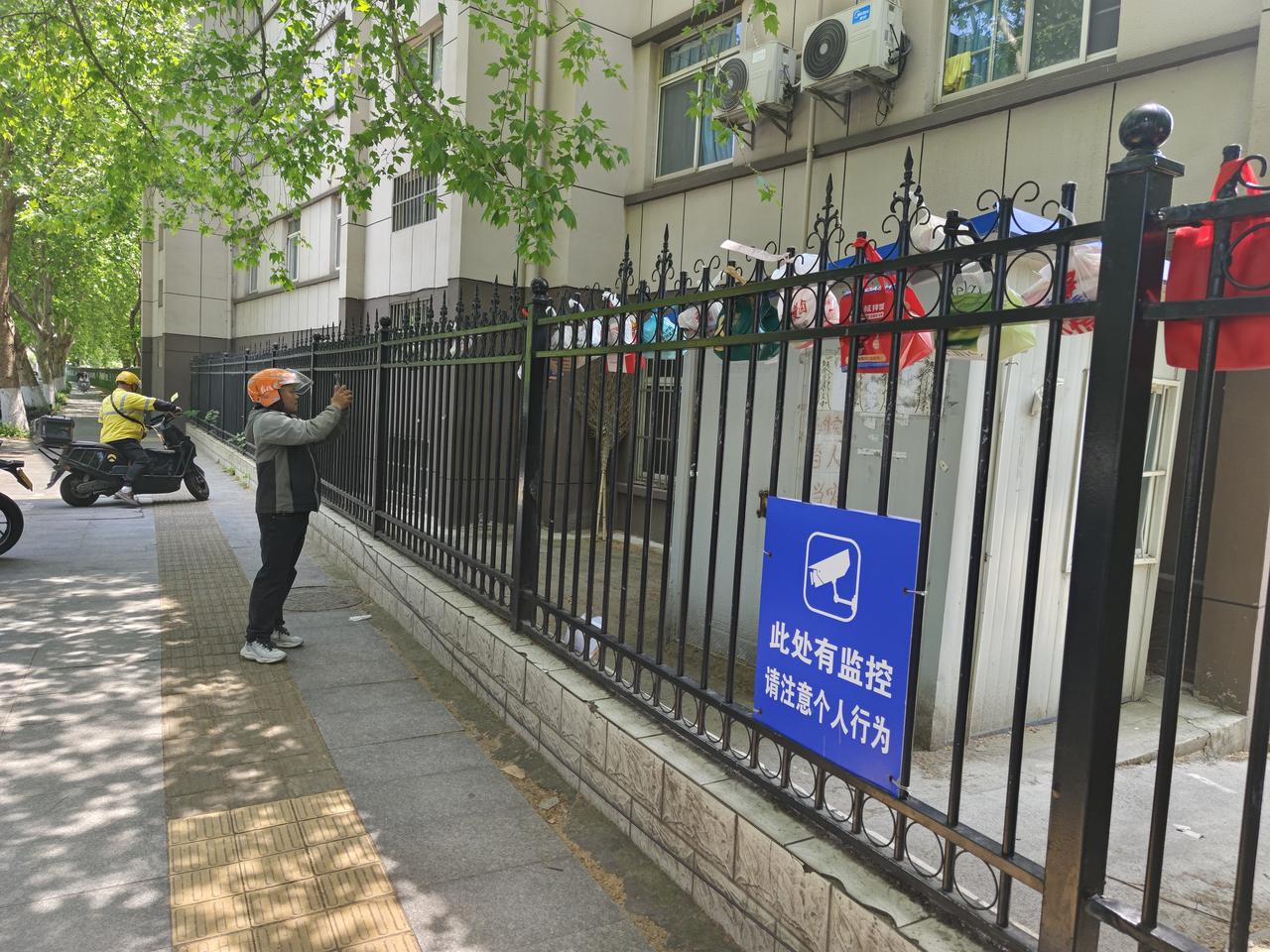 这是在镇江北固山附近一居民小区外，见到的暖心一景。
外卖小哥与订餐人无接触式完成