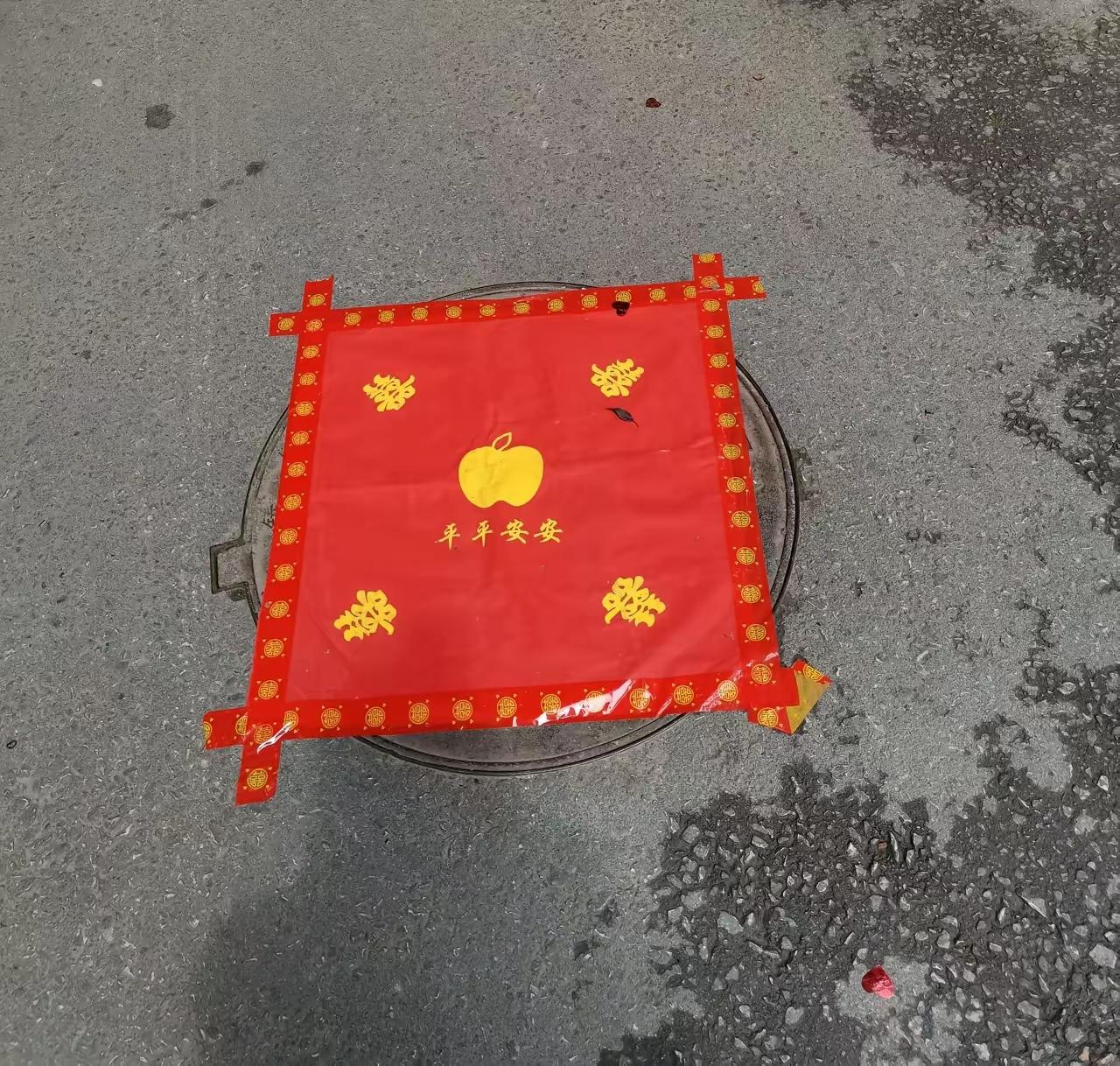 一户办喜事，小区二十多个井盖全被红纸糊死了。

一个没落，红得瘮人。

打听了一