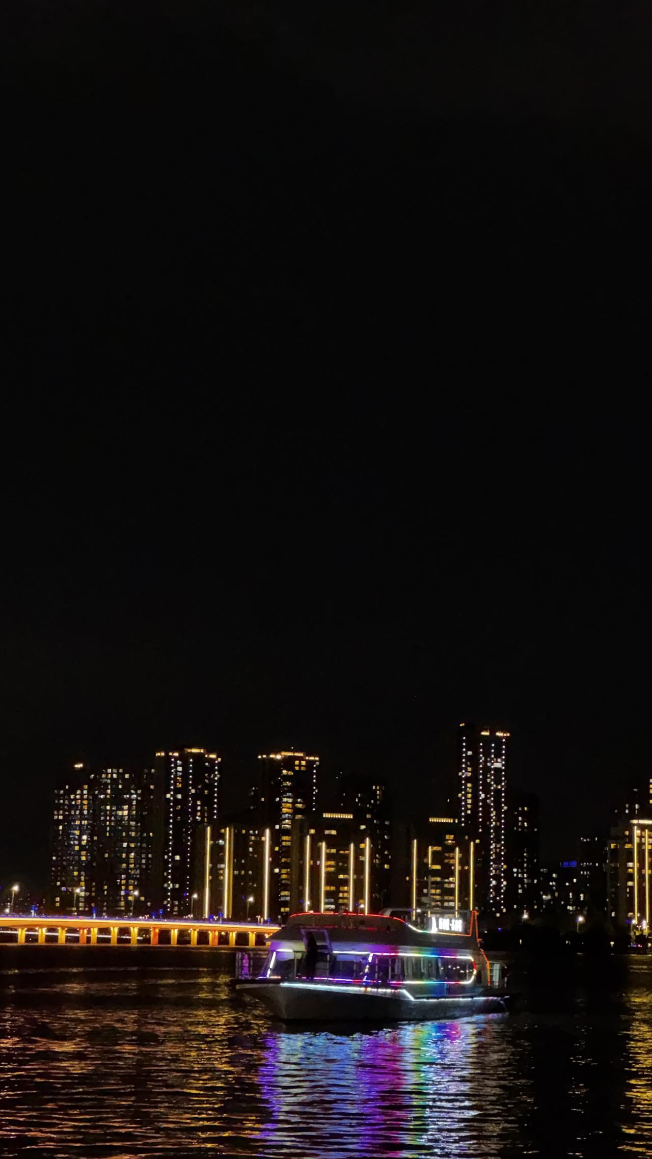 分享一张最近随手拍的照片霓虹落水面，孤舟渡良宵，城市灯火阑珊，游船载着人间晚风。