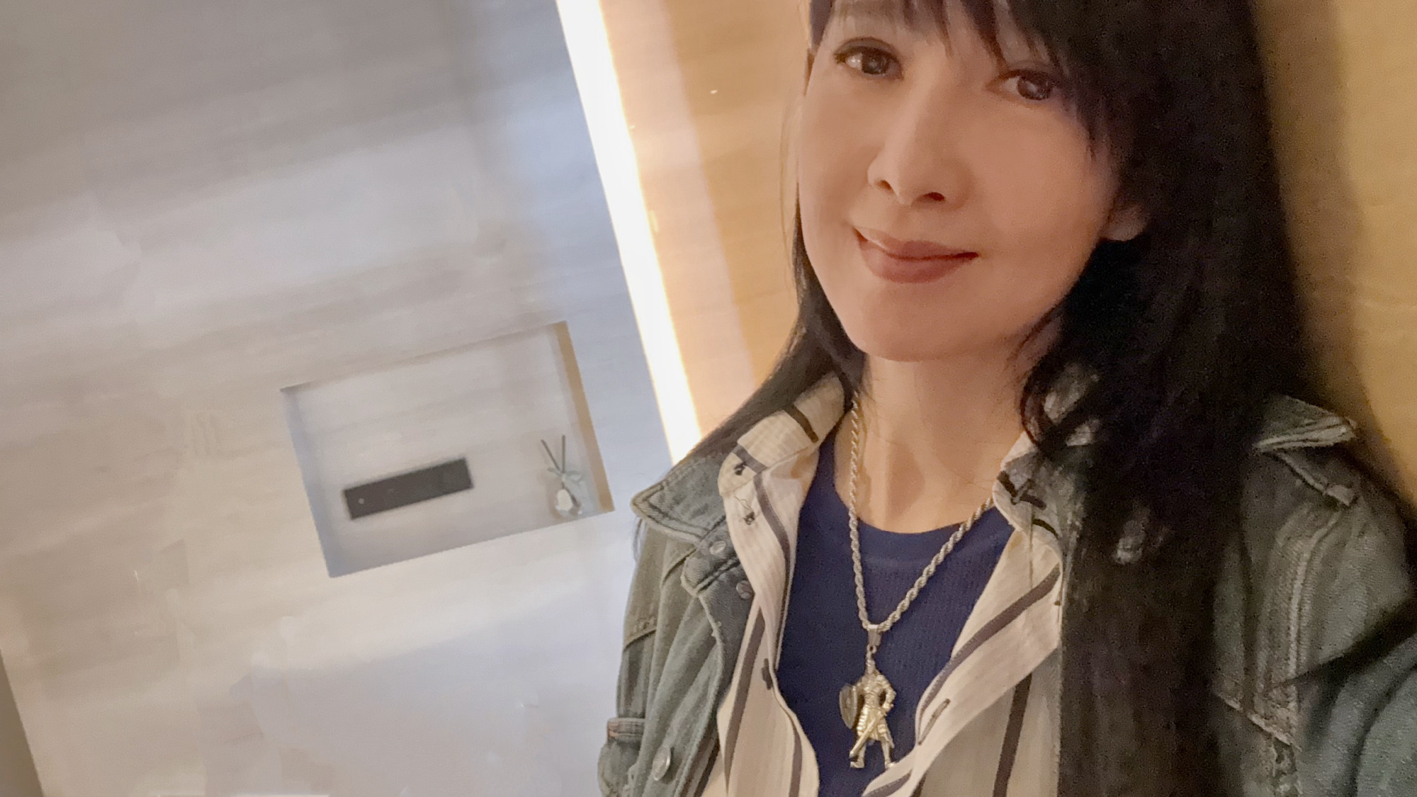 周慧敏 一袭丹唇浅带柔，乌丝垂鬓衬清眸。牛仔叠衫添疏朗，银链悬雕蕴静悠。素壁柔光