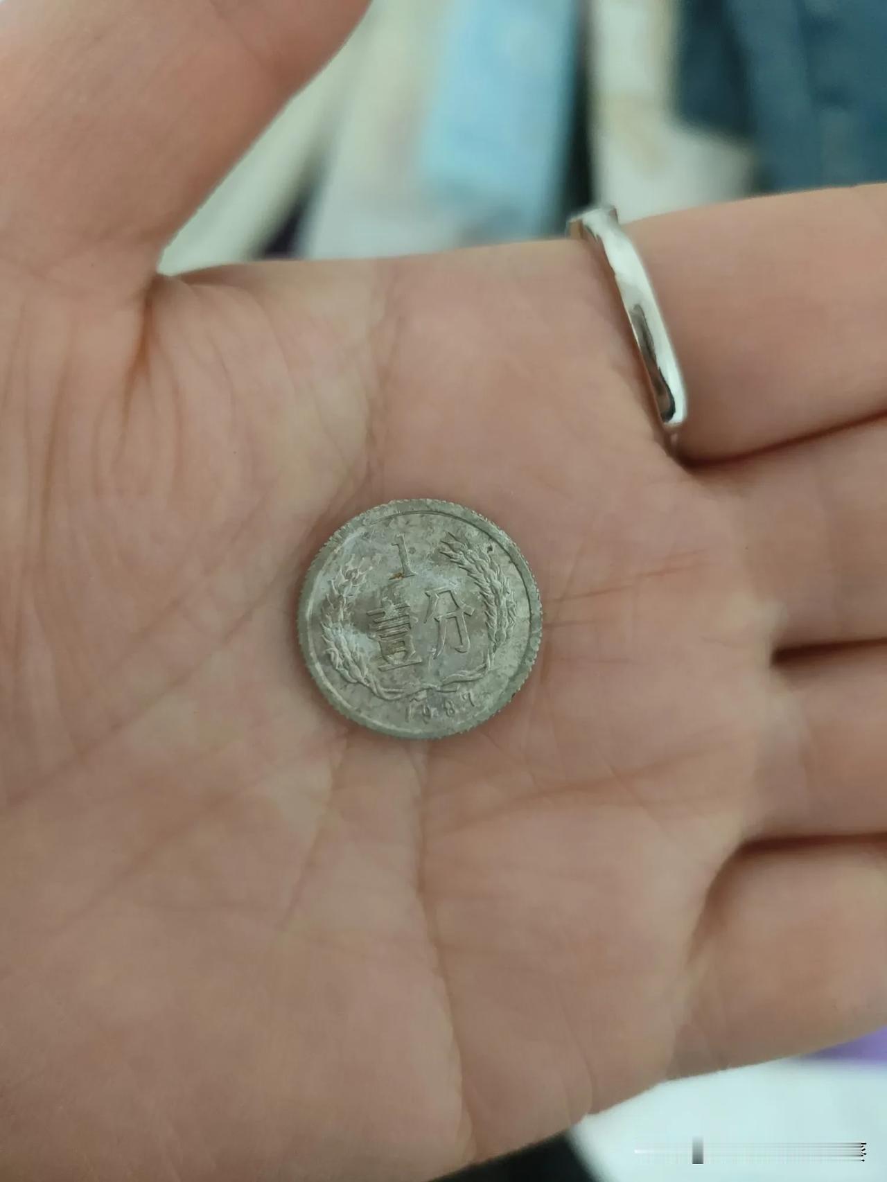 翻老抽屉翻出枚壹分硬币，边都磨圆了，字也快看不清。小时候攥着几枚能换糖吃，能跟小