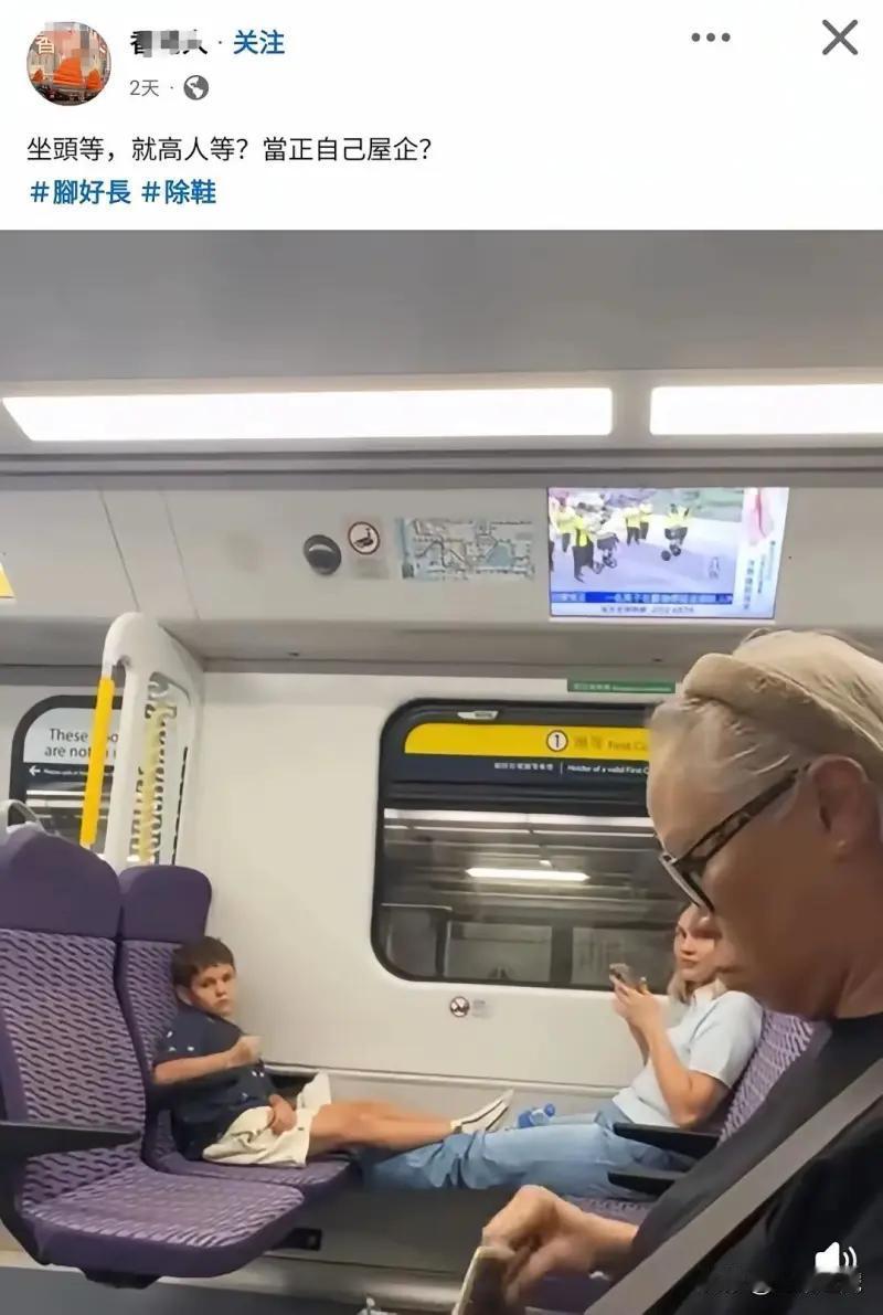 这张照片记录了香港港铁头等车厢里的一幕：一名小男孩脱掉鞋子，将脚搭在对面的空座位