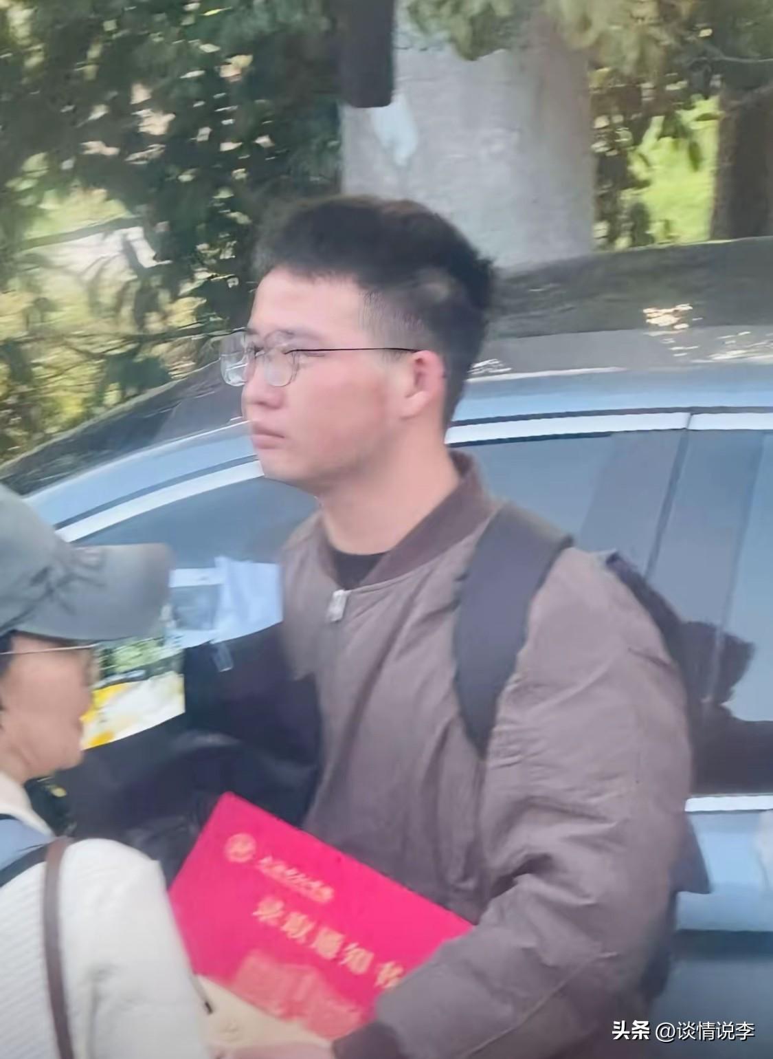 人群中，这位朴素的小伙子看哭了无数人。他抱着自己的录取通知书，跟随着大家的脚步。