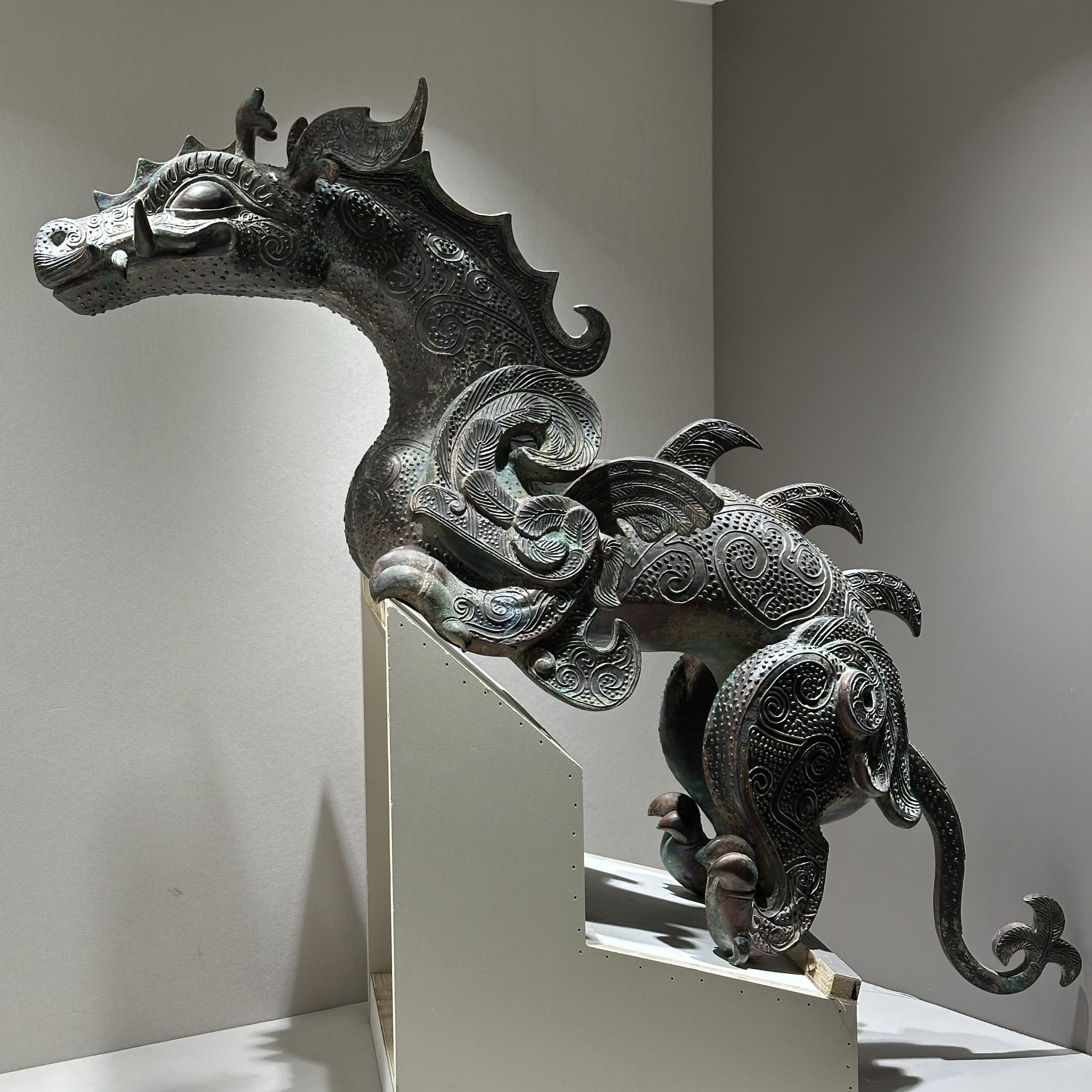 青铜龙镇。这件青铜器通身布满细密的蟠虺纹与云纹，每一道纹路都由失蜡法精...