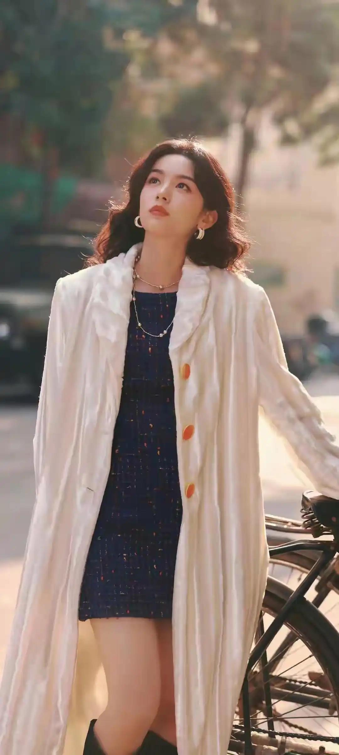你感觉杨幂哪里漂亮吗都市时尚女孩，白色大衣搭配蓝色连衣裙，复古自行车旁，阳光洒落