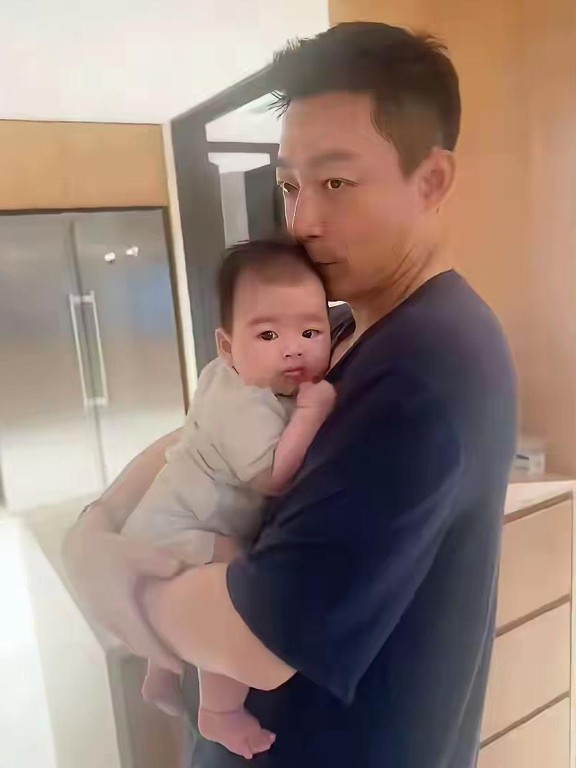 他抱着自己的第三个孩子，目光呆滞，脑子里也许是另一种话画面——那年那月那日，他淋